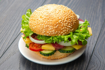 Hamburger with vegetables and sausage. Fast food and breakfast. Calories and diet.