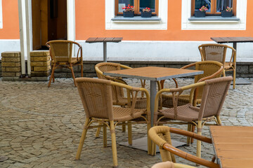 Wooden restaurant table and chairs set outside for clients.