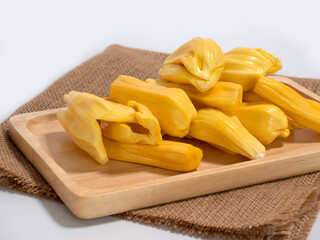 Fresh jackfruit slices on a wood plate.