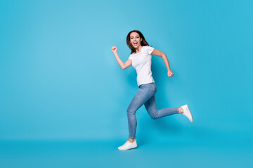 Fototapeta na wymiar Full length body size profile side view of nice active sportive slim fit skinny cheerful cheery girl jumping running spring action movement isolated bright vivid shine vibrant blue color background