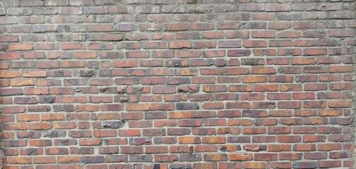 a rough brick wall consisting of red bricks