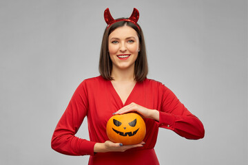 holiday, theme party and people concept - happy smiling woman in red halloween costume of devil...