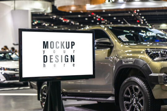 Mockup blank white screen LCD TV with blurred background of car in car exhibition or motor show or motor show. Mock up for your sales promotion advertisement, announcement, branding presentation, mark