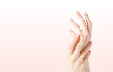 Closeup image of beautiful woman's hands with light pink manicure on the nails. Beautiful Woman Hands. Female Hands Applying Cream, Lotion. Spa and Manicure concept. Elegant and graceful hands.