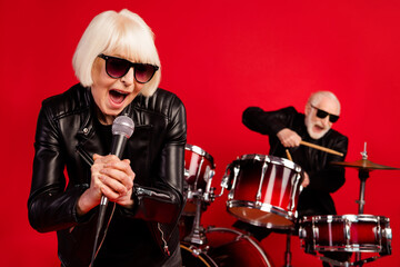Portrait of two retired pensioner retired people woman sing composition solo man play drum...