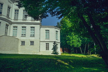 Picturesque place of white. Palace with pond and green trees.