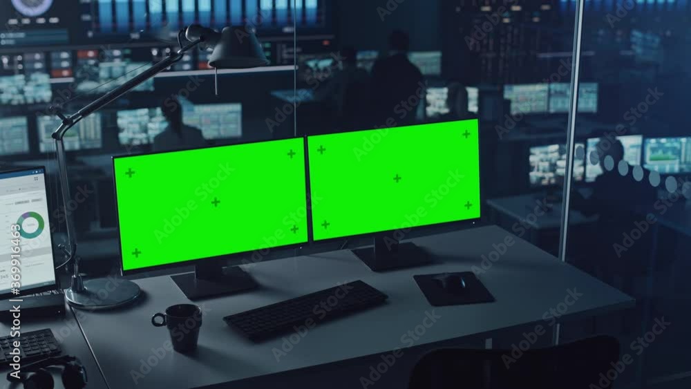 Aufkleber Two Digital Computer Screens with a Green Mock Up Chromakey in Modern Monitoring Office. Control Room with Specialists and Managers Sit in Front of Computers. 
