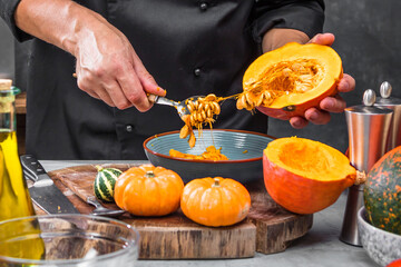 partial view of chef chopping fresh organic pumpkins