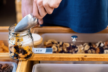 Man in supermarket with jar taking goodies