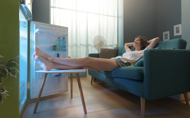Fototapeta Woman cooling herself in front of the open fridge obraz