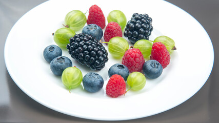 Assorted fresh different berries on a white plate. useful vitamin healthy food fruit. healthy vegetable breakfast