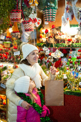Ordinary mother with small daughter in Christmas market. High quality photo