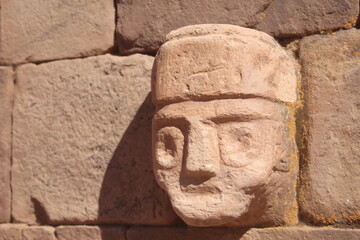 Fototapeta na wymiar stone carving of a man in faces wall in tiwanaku bolivia