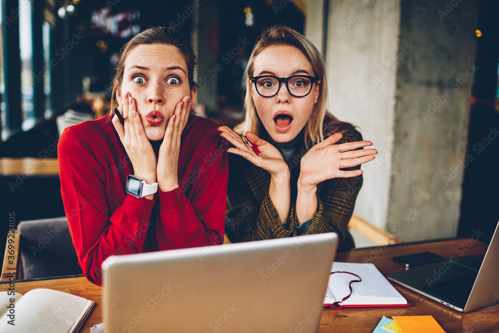 Poster half length portrait of excited hipster students shocked with big sales on website.emotionally amaze