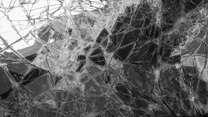 The broken windshield of the car. Glass splinter. An accident with the car. Dangerous traffic accident. Road accident. Glass background. Black and white photography.