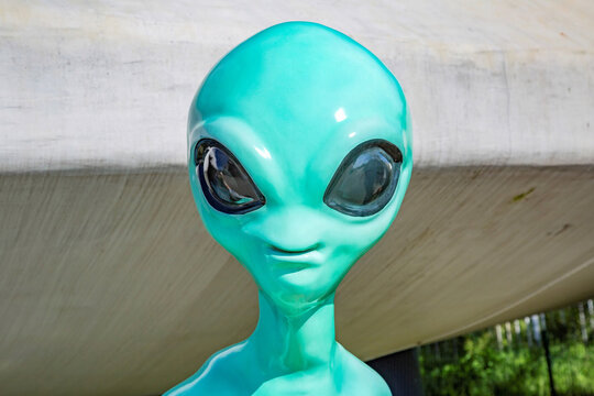 Turquoise plastic toy alien with big black eyes