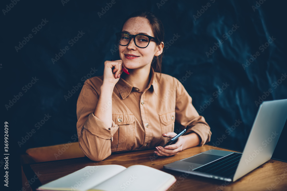 Aufkleber half length portrait of happy female graphic designer in eyeglasses smiling at camera while holding 