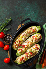 Healthy food. Baked zucchini stuffed with meat and tomatoes in a cast iron pan. Top view flat lay background. Copy space.