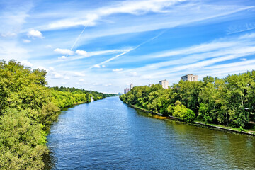 picturesque moscow city moskva river canal nature landmark with forest park scenery reflection on water against blue sky background. Urban landscape. Summer in city. Wide view