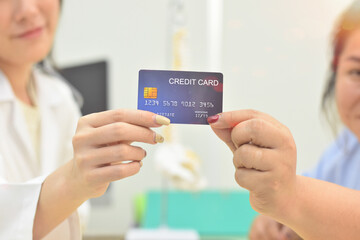 The close up view a mockup credit card in hand holding by doctor with patient in hospital, health care concept,