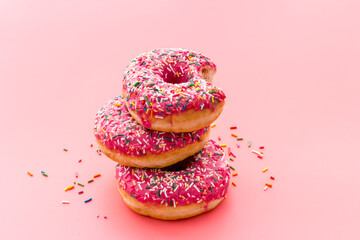 Pink berry donuts close up. Glazed and sprinkles bakery