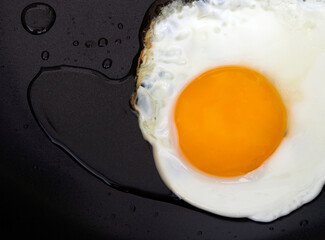 fried egg with oil on pan 