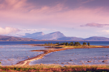 Fjord at sunset. Rocky seashore in the evening.  Beautiful nature of Norway. Picturesque Scandinavian landscape. Lofoten islands, Norway, Europe