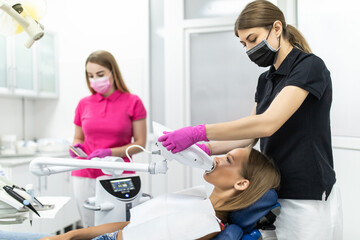 Teeth whitening for woman in dentist office. Bleaching of the teeth at dentist clinic.