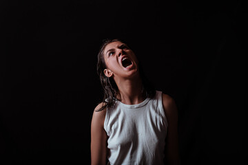 Young crying woman on a dark background
