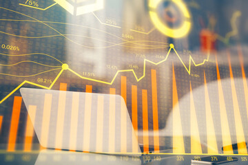 Stock market graph on background with desk and personal computer. Multi exposure. Concept of financial analysis.