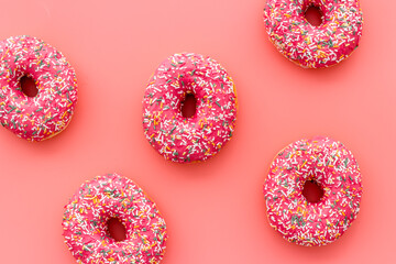 Donuts flat lay pattern on pink background, top view