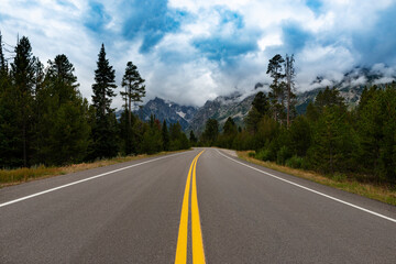 Fototapeta premium Scenic view of a road with the Grand Teton mountains on the background, in the State of Wyoming, USA