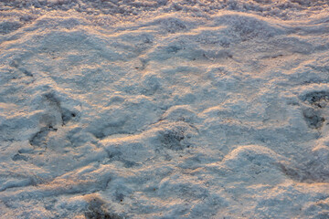 Salty sea coast. Sea salt salt farm. The shore is covered with salt deposits on a pink lake.