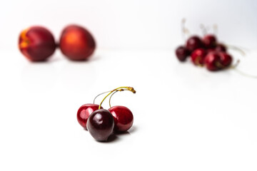 Obraz na płótnie Canvas Soft focus on red cherries on a white background. Copy space around isolated fresh organic fruits. Healthy food from nature. Fruits for desserts.