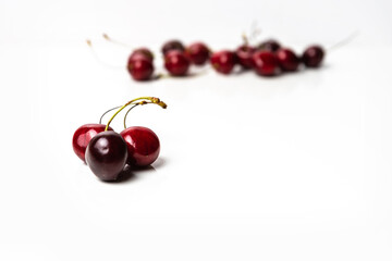 Obraz na płótnie Canvas Handful of red cherries on a white background. Copy space around isolated fresh organic sweet cherry berries. Healthy food from nature. Fruits for desserts.