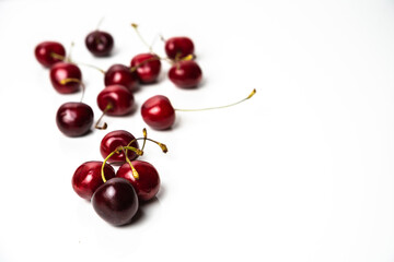 Obraz na płótnie Canvas Bunch of red cherries on a white background. Copy space around isolated fresh organic sweet cherry berries. Healthy food from nature. Fruits for desserts.
