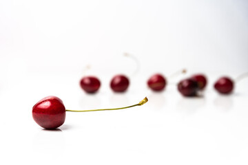 Naklejka na ściany i meble Soft focus on red cherry on a white background. Healthy food from nature. Copy space around isolated fresh organic fruits. Fruits for desserts.