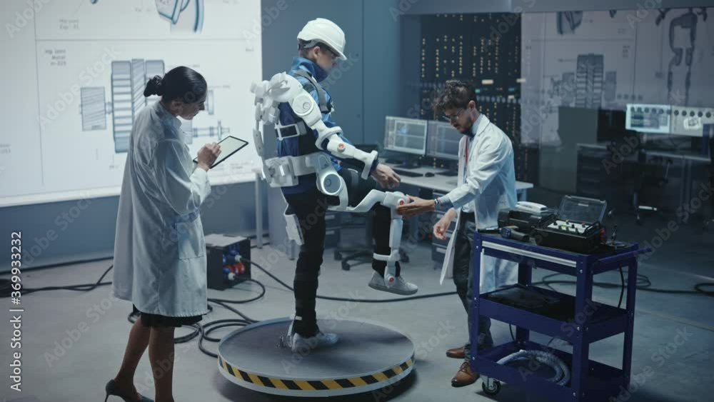 Poster In Robotics Development Laboratory: Engineers and Scientists Work on a Bionics Exoskeleton Prototype with Person Testing it. Designing Wearable Exosuit to Help Disabled People, Warehouse Workers
