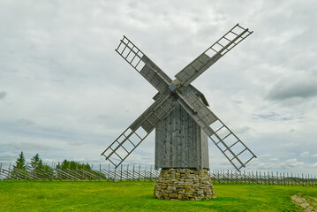 Old vintage wooden windmill in the background of the cloudy sky. Saaremaa, Estonia.