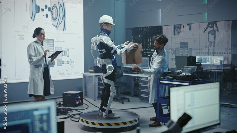 Aufkleber In Development Laboratory: Engineers Work on a Robotic Exoskeleton with a Person Testing it by Trying to Lift Heavy Cardboard Box. Designing Wearable Exosuit to Help Hard Labor Warehouse Workers