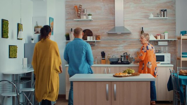 Young couple broughting the purchases from the store. Husband and wife coming from shopping bringing a paper bag with groceries, fresh food from supermarket at parents home to prepare family dinner