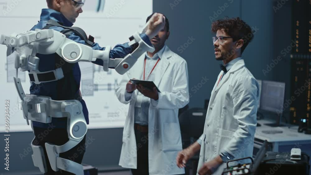Leinwandbilder In Robotics Development Laboratory: Engineers and Scientists Work on a Bionics Exoskeleton Prototype with Person Testing it. Designing Wearable Exosuit to Help Disabled People, Warehouse Workers
