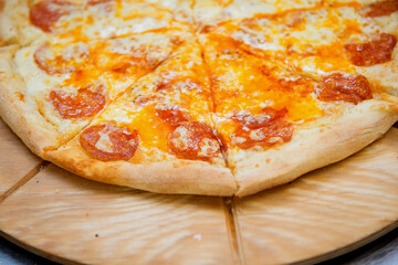A chunk of pepperoni pizza cut into pieces, close-up.