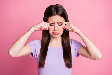 Photo of displeased crying stressed sorrow lady student wipe tears arms fingers upset sad gloomy miss parents family want come home wear purple t-shirt isolated pastel pink color background