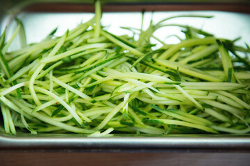 Sliced cucumbers in a container for cooking, close-up.