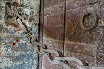 Old rusty chain and massive wrought iron doors