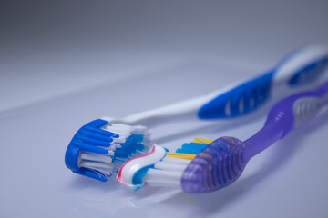 two toothbrushes on a white background next to the toothpaste. healthy and clean teeth concept, dentistry. High quality photo