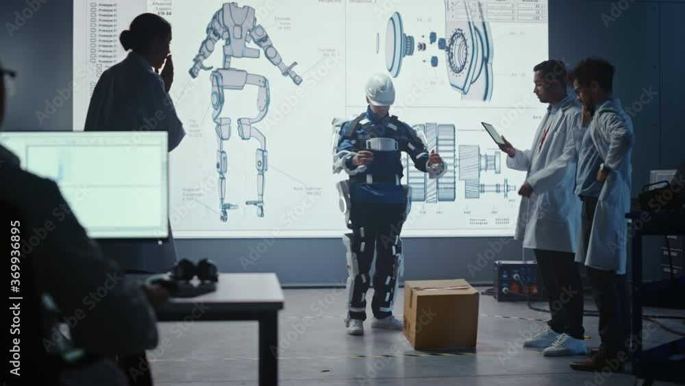 Poster In Development Laboratory: Engineers Look at Robotics Exoskeleton Presentation with Person Lifting and DroppingHeavy Carboard Box, Disappointed Scientists are Upset