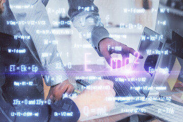 Fototapeta premium Science formula hologram with man working on computer on background. Education concept. Double exposure.