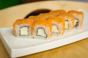 Sushi with salmon on a white plate on the table, close-up. Japanese food.
